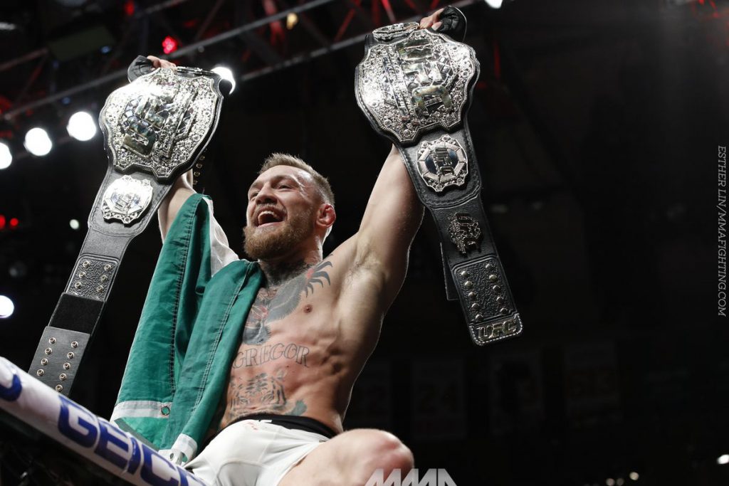 Conor McGregor hoists both of his belts after defeating Eddie Alvarez to become the double champ of the UFC.