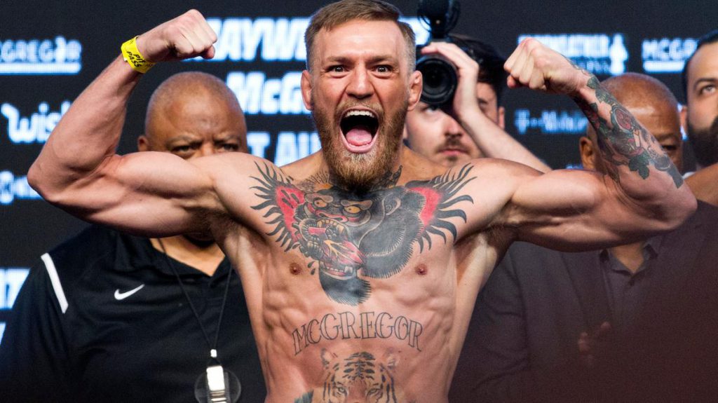 Conor McGregor flexes his muscles and roars during a UFC weigh in