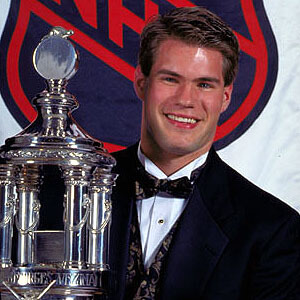 Jim Carey holds the Vezina Trophy in 1996 just as Carter Hart hopes to someday in the future