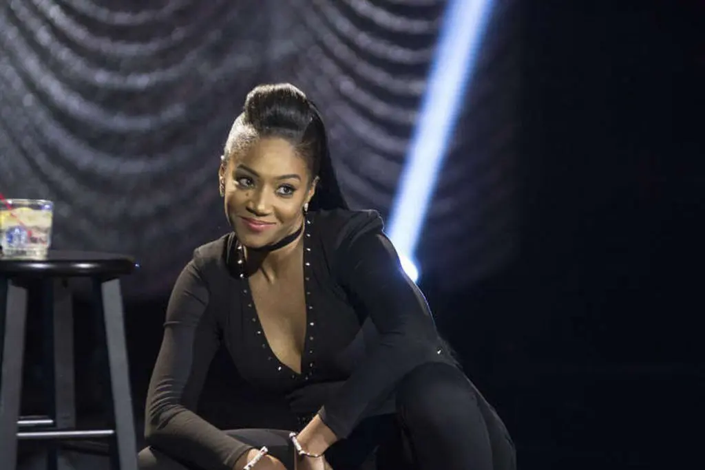 Tiffany Haddish bends down and gazes into the crowd with a smirk on her face during her Showtime Comedy Special.