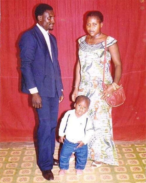 Francis Ngannou stands with his parents as a small child in Cameroon.